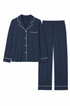 A two-piece navy blue pajama set with white piping details, including a long-sleeve button-up top with a chest pocket and matching straight-leg pants.