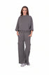 Woman wearing a gray outfit with a top and cargo pants on a white background
