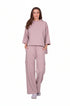 Woman wearing a pink outfit with a top and pants on a white background